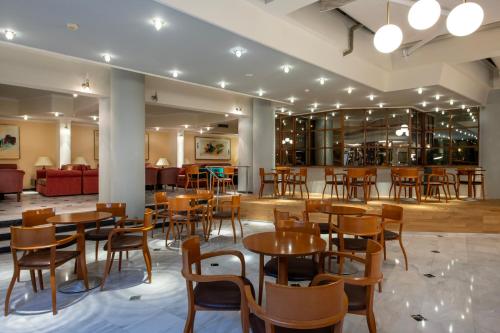a restaurant with tables and chairs and a bar at Hydramis Palace Beach Resort in Georgioupolis