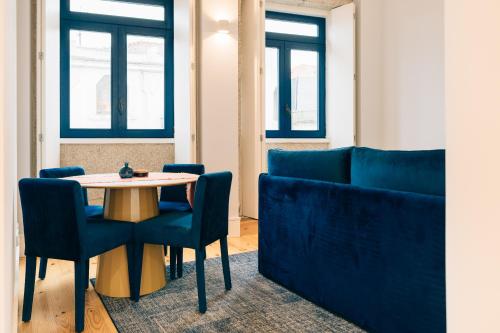 une table et des chaises dans une pièce avec fenêtres dans l'établissement ORM Padrão Apartment, à Porto