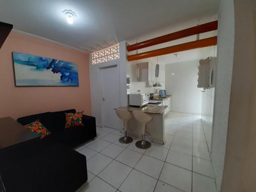 un salon avec un canapé et une cuisine dans l'établissement Maitinga SESC Bertioga, à Bertioga