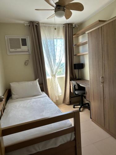 sypialnia z łóżkiem, biurkiem i oknem w obiekcie Condotel DC MARINA SPATIAL FELINVEST w mieście Dumaguete