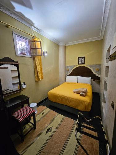 a bedroom with a yellow bed and a chair at Dar Bargach in Tangier