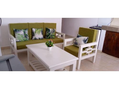 ein Wohnzimmer mit 2 Stühlen und einem Tisch in der Unterkunft Swayp Mtwapa Furnished Apartment, Mombasa in Mombasa