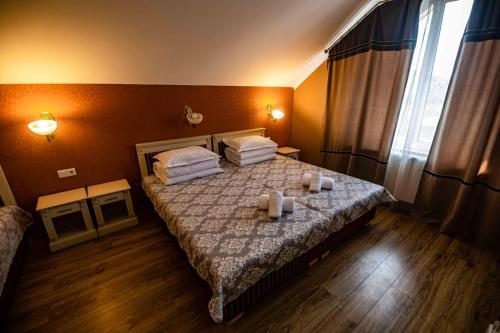 1 dormitorio con 1 cama con toallas y velas en Pensiunea Venetia Sighisoara en Sighişoara