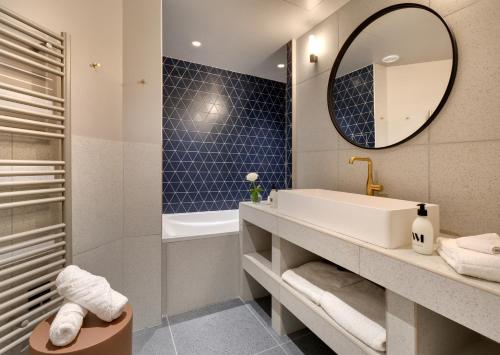 uma casa de banho com um lavatório e um espelho em Artemisia Montmartre em Paris