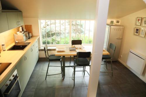 a kitchen with a table and chairs in a kitchen at Suite Garden by La Boîte En Plus in Senlis