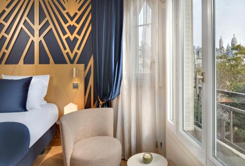 a bedroom with a bed and a window and a chair at Hôtel Artemisia Montmartre in Paris