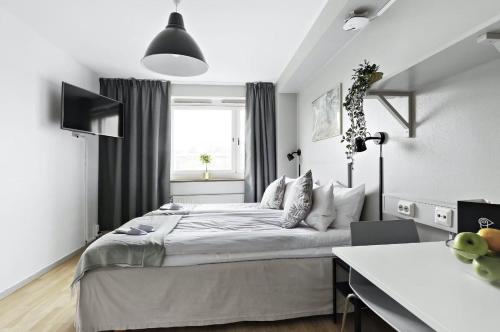 una camera con un grande letto e una finestra di Forenom Aparthotel Stockholm Alvik a Stoccolma