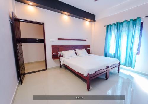 a bedroom with a bed and a mirror at Prime Casadel Rooms And Apartments in Kakkanad