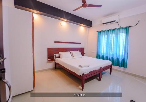a bedroom with a bed and a ceiling fan at Prime Casadel Rooms And Apartments in Kakkanad