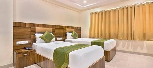 a hotel room with two beds and a window at Hotel Mumbai International- Near T2 International Airport in Mumbai