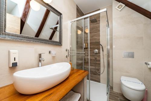 een badkamer met een witte wastafel en een douche bij B&B Villa Sumrak Plitvica Rooms in Plitvička Jezera