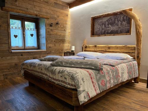 1 dormitorio con 1 cama en una habitación con paredes de madera en Bed and Breakfast Campo Base, en Carona