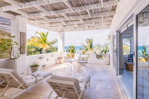 an open living room with chairs and a table at Villa Santorini in Vilanculos