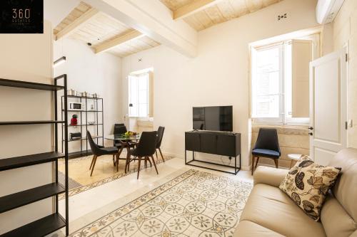 uma sala de estar com um sofá e uma mesa em Historical Mdina Gem, Lux HOME with Rooftop Pool by 360 Estates em Mdina