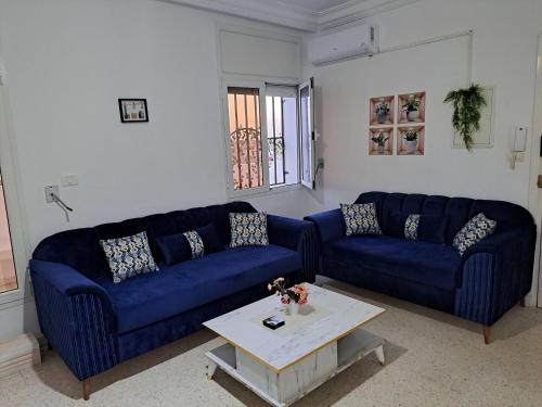 a living room with two blue couches and a table at Residence Rahma 