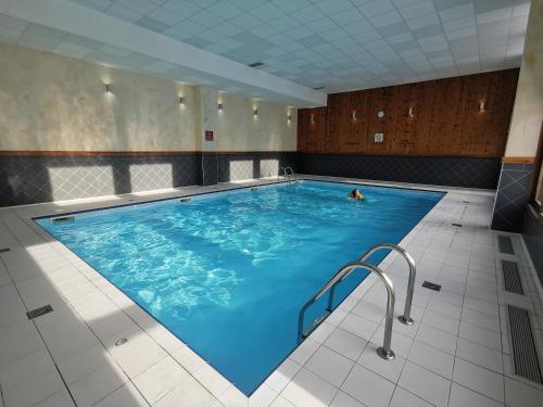 una persona che nuota in una grande piscina coperta di Le Crey du Quart a Valmeinier