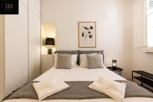 a bedroom with a large white bed with two towels on it at Historical Mdina Gem, Lux HOME with Rooftop Pool by 360 Estates in Mdina