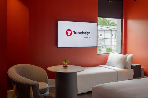 a hotel room with a bed and a table and a chair at Travelodge Nimman in Chiang Mai