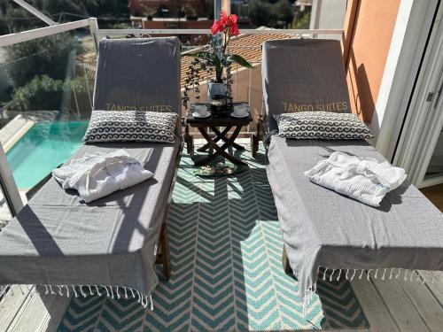 two chaise lounges on a deck next to a pool at Tango Apartment On The Beach in Paleokastritsa