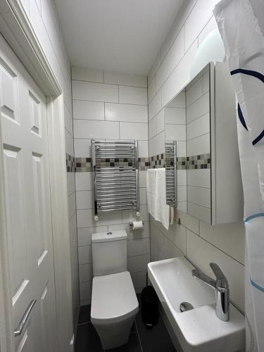 a white bathroom with a toilet and a sink at Sia Apartments Hotel in Essen
