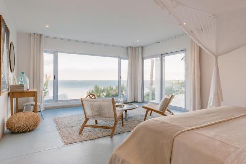 Villa Santorini في فيلانكولوس: غرفة نوم مع سرير وإطلالة على المحيط