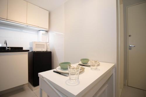 a kitchen with a table with glasses on it at Studio na melhor quadra da Asa Norte in Brasilia