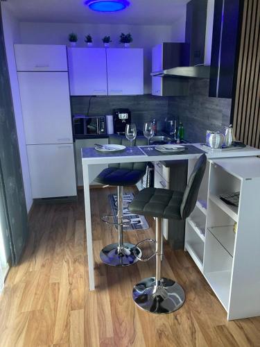 a kitchen with a counter with two bar stools at Home- Alt-Winzerla in Jena