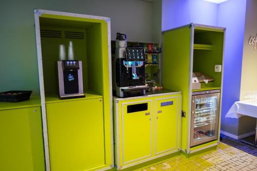 a room with two yellow machines and a refrigerator at flexymotel Wil in Wil