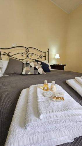a bed with a white blanket and two drinks on it at La Locanda Del Castello 