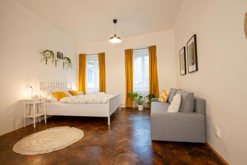 White Wolf House Hostel & Apartments في براغ: غرفة نوم بسرير واريكة وكرسي