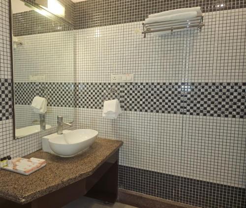 a bathroom with a sink and a mirror at Aarunya Hotel And Resort in Rājgīr