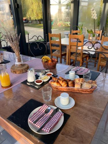 a table with a breakfast of bread and eggs at Les Mariniers Chambres d'Hôtes à la campagne avec aire de jeux - Spa nordique en option in Mareuil-sur-Cher