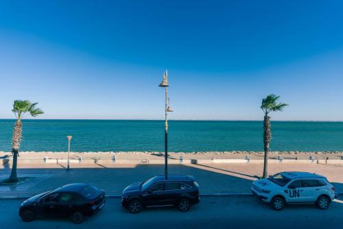 three cars parked in a parking lot near the beach at PLAYA Hôtel & Restaurant Dakhla in Dakhla