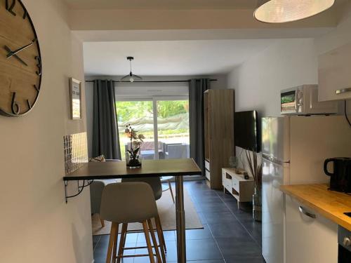 une cuisine avec une table et une horloge au mur dans l'établissement Le Cocon - grande terrasse - calme - proche gare, à Nancy