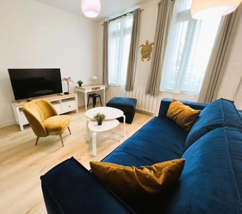 een woonkamer met een blauwe bank en een tv bij Villa Saint Jacques , Duplex Les Galets in Le Tréport