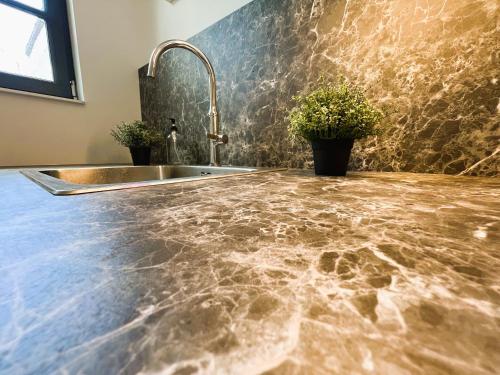 een keuken met een marmeren aanrecht en een wastafel bij Villa Saint Jacques , Duplex Les Galets in Le Tréport