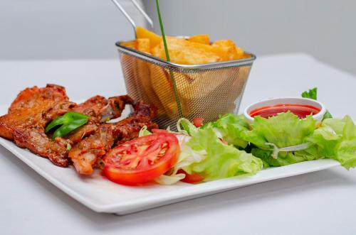 a plate of food with meat lettuce and tomato at ROYAL SHALOM HOTEL in Lusaka