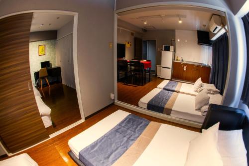 a bedroom with a large mirror in a room at e-stay namba in Osaka