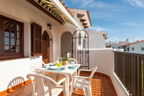 a patio with a white table and chairs on a balcony at Apartamentos en Son Bou in Son Bou
