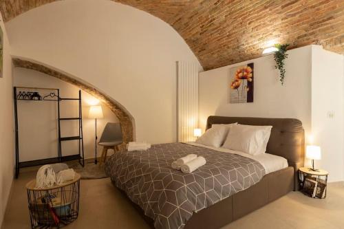 um quarto com uma cama e uma parede de tijolos em Seguri _ Loft Rustico [FreeParking] em Capolago