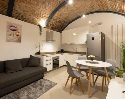 cocina y sala de estar con sofá y mesa en Seguri _ Loft Rustico [FreeParking], en Capolago