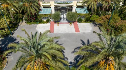 an empty parking lot with palm trees in front of a building at Hydramis Palace Beach Resort in Georgioupolis