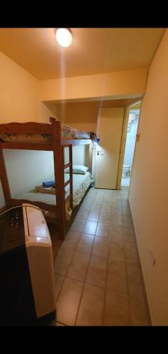 Pokój z 2 łóżkami piętrowymi i podłogą wyłożoną kafelkami w obiekcie a 3 MIN DEL CENTRO w mieście Concordia