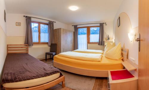 a hotel room with two beds and a desk at Landhaus Toni in Neustift im Stubaital