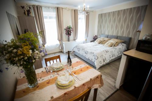 ヴァウブジフにあるamazing DECO center Walbrzychのベッドルーム1室(ベッド1台、花のテーブル付)