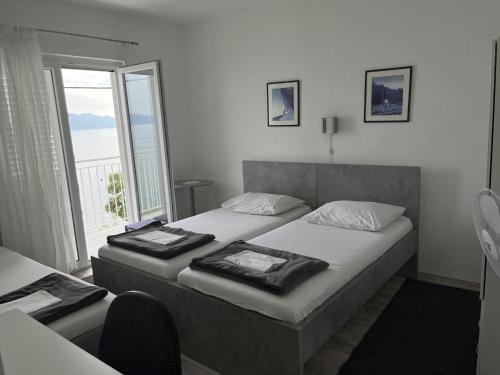 a bedroom with two beds and a large window at Apartments Gaspar in Podaca