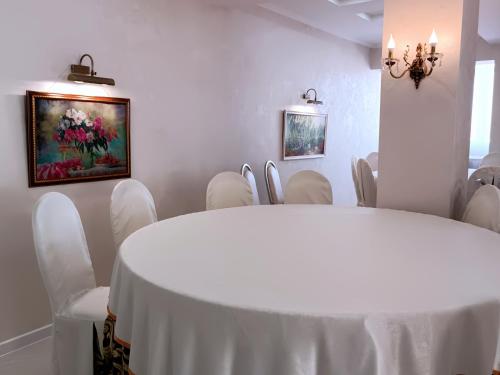 a white room with a white table and chairs at Hotel & Banquet Hall SV Airport Parkway in Todoreshty