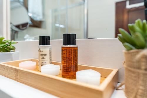 a wooden tray with three bottles of moisturizing products on a bathroom counter at B&B Villa Sumrak Plitvica in Plitvica selo