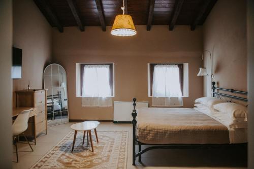 een slaapkamer met een bed, een tafel en een stoel bij Agriturismo Pizzavacca in Villanova sullʼArda