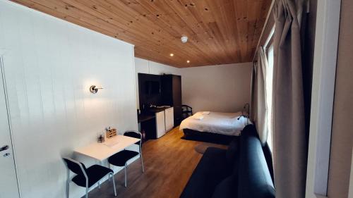 Zimmer mit einem Bett, einem Tisch und Stühlen in der Unterkunft Telemark Motel and Apartment in Hauggrend